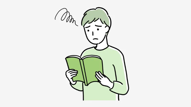 困り顔で読書する男性